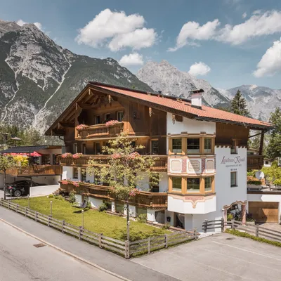 Charming alpine guesthouse with wooden balconies and flower boxes in a scenic mountain village